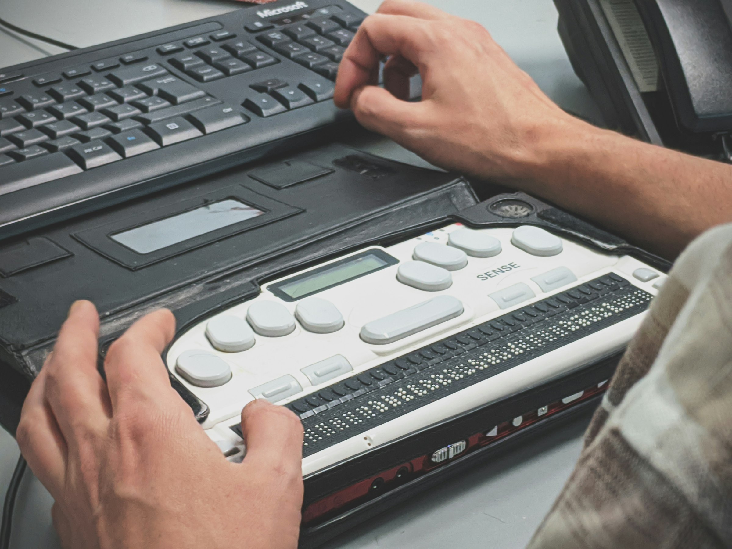 A person using a braille display, representing assistive technology that AI-assisted accessibility work must be validated against.